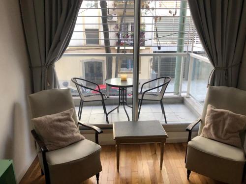布宜诺斯艾利斯Cozy Apartment in Nuñez的配有椅子和桌子的房间以及窗户