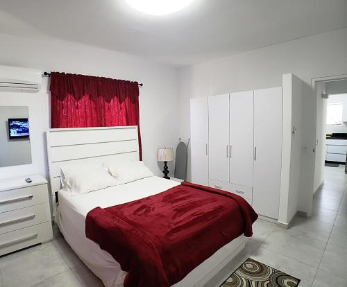 奥拉涅斯塔德Aruba Vacation House - Cozy and Modern!的一间卧室配有一张大床和红色窗帘