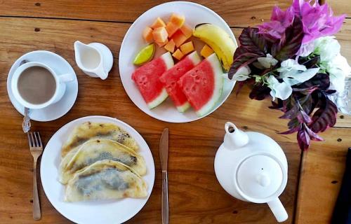 比拉Bara Beach Bungalows的餐桌,带两盘食物和一杯咖啡的桌子