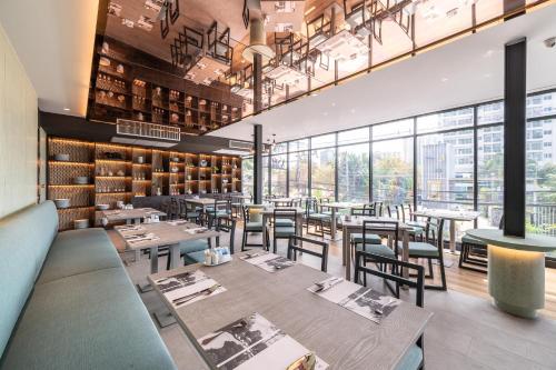 北芭堤雅Manhattan Pattaya Hotel - SHA Extra Plus的餐厅设有桌椅和窗户。