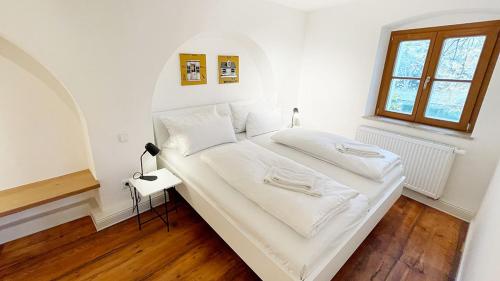 雷根斯堡Wassergasse 11的一间卧室配有一张带白色床单的床和一扇窗户。