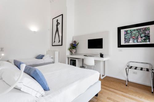 冯塔尼比安奇Calapetra Resort的一间白色卧室,配有两张床和一张书桌