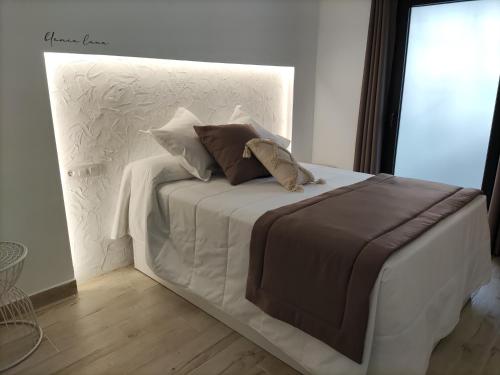 梅里达PIEDRA DE LUNA的一张白色的床,上面有两个枕头