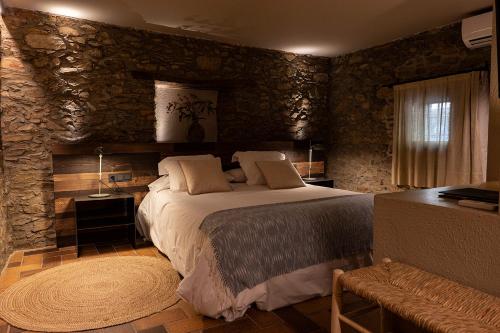 蒙塞尼坎巴林纳酒店的一间卧室设有一张床和石墙