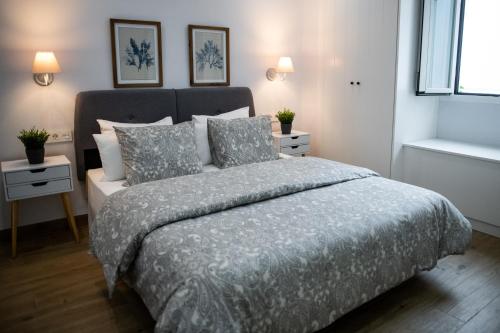 圣玛丽亚港Apartamentos Nueva Ribera的一间卧室配有一张带灰色棉被和枕头的床