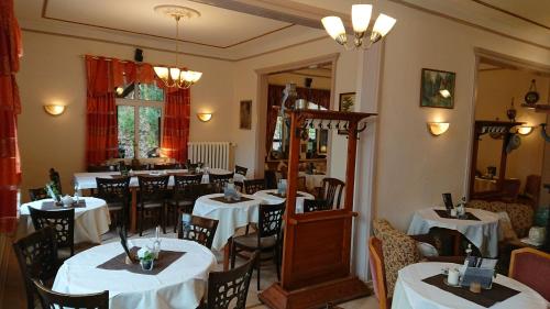 腓特烈罗达Pension Waldschlösschen的一间餐厅,房间内设有白色的桌椅