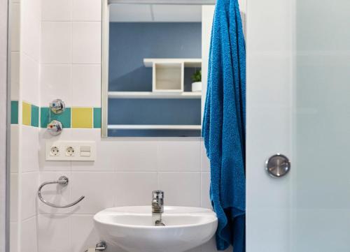 潘普洛纳阿尔伯格拉拉奥纳旅舍的一间带水槽和蓝毛巾的浴室