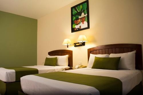 比亚埃尔莫萨Tabasco Inn的绿墙旅馆客房的两张床