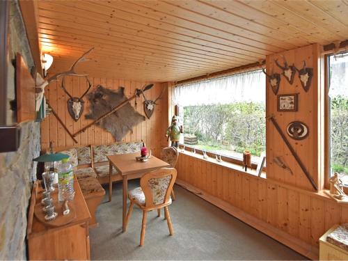 WeitersglashütteHoliday home with sauna in Wildenthal的客房设有桌椅和窗户。