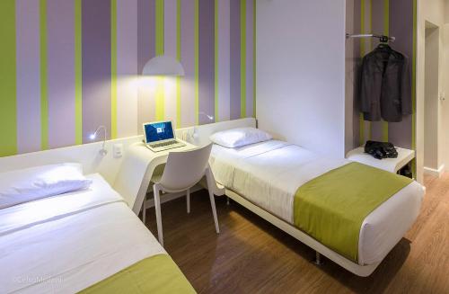 马里利亚德马科斯酒店的客房设有两张床和一张带笔记本电脑的书桌。