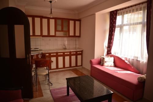 克孜勒贾哈马姆AKASYA VADİSİ的一间带红色沙发的客厅和一间厨房