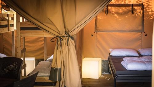 贝尔多夫Safari Tent XL Camping Belle-Vue的客房设有两张双层床和一盏灯。