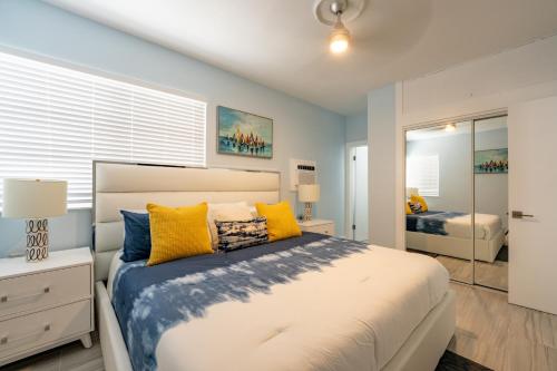 好莱坞The Surf Hollywood Beach的一间卧室配有一张大床,提供黄色和蓝色的枕头