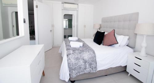 德班1002 Bermudas - by Stay in Umhlanga的白色卧室配有床和镜子