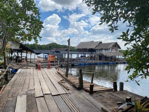 双溪大年CabinStay Cikgu Sungai Batu Besi的水面上带房子的木甲板