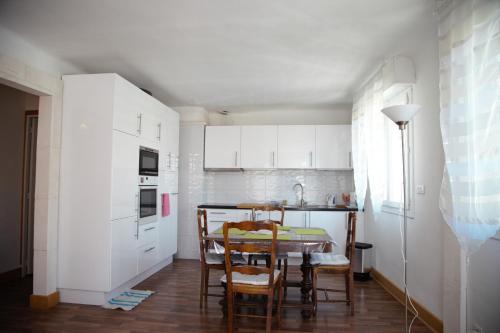 阿尔勒Laincel - Clim - Balcon的厨房配有白色橱柜和桌椅