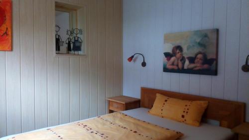 DerenburgHalmis FeWo的卧室配有一张床,墙上挂着一幅画