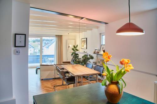 代德斯海姆Klimatisierte Wohnung mit großer Terrasse的一间带桌子和花瓶的用餐室