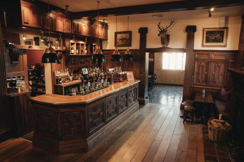 纽波特The Swan Hotel的一间酒吧,位于一间铺有木地板并配有木制橱柜的客房