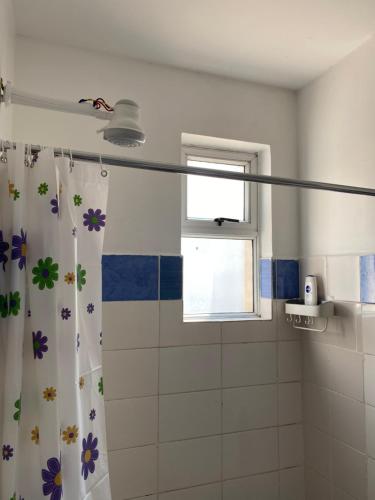 内罗毕Lyshima’s Cozy Studio的浴室设有鲜花和淋浴帘。