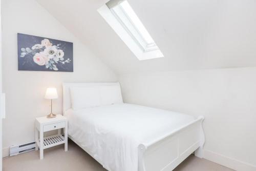 温哥华West Coast Luxury Living的一间白色卧室,配有床和床头柜