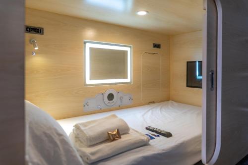 圣克鲁斯-德拉帕尔马HosteLit, Capsule Hostel的小房间设有一张带毛巾的床和一台电视机