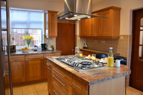 诺里奇St Marys House的厨房配有木制橱柜和炉灶烤箱。