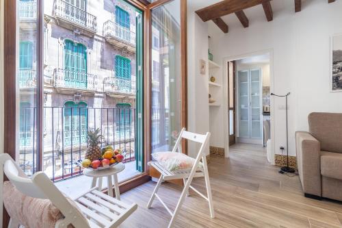 马略卡岛帕尔马坎博思图里斯莫因特廖尔公寓的客厅配有桌椅和窗户。