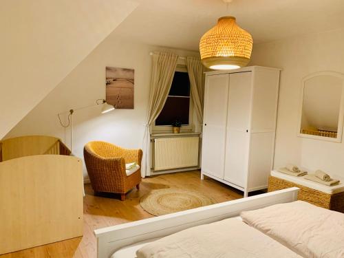索尔陶Ferienwohnung HeideZeit Soltau - Neu mit Spielturm的一间卧室配有一张床、一把椅子和一个橱柜