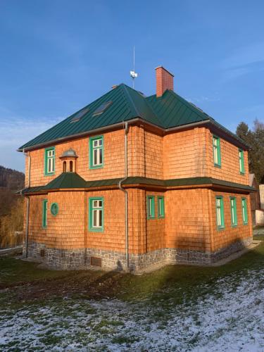 HraběšiceChata Klášter的一座带绿色屋顶的大型砖屋