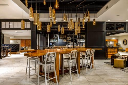 夏洛特Sonesta Charlotte Executive Park的餐厅设有带凳子的大型木制酒吧