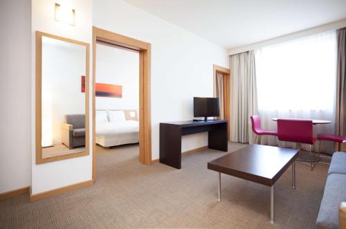 巴利亚多利德Sercotel Valladolid的酒店客房设有沙发、桌子和镜子