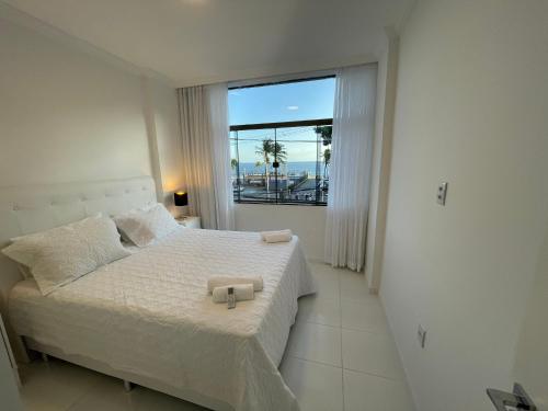 萨尔瓦多SALVADOR Ondina 3 quartos frente praia的一间卧室设有一张床和一个大窗户