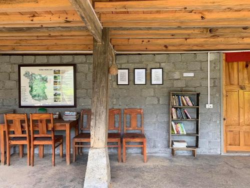 河江Nậm Lỳ Retreat- Breakfast included的配有桌椅和书架的房间