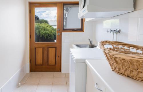 潘尼萧博丹楼度假屋的白色的厨房设有水槽和门