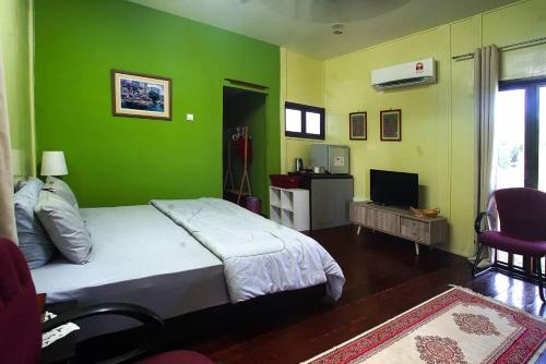 MerlimauLaman Sakinah Merlimau的一间卧室设有一张床和绿色的墙壁