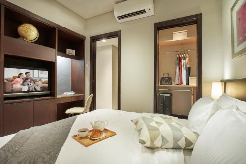 新加坡Somerset Bencoolen Singapore的一间卧室配有一张床,上面放着一个食物托盘