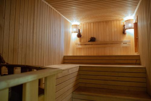 UznezyaАйбарка的墙上设有木镶板和灯的桑拿浴室