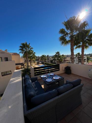 圣哈维耶尔Magnifique appartement dans Roda Golf (phase 4)的棕榈树阳台的沙发和桌子