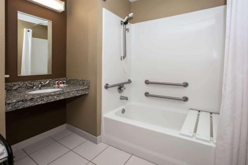 佩科斯Microtel Inn and Suites Pecos的浴室配有白色浴缸和水槽