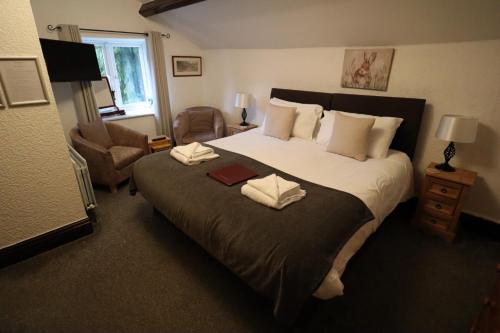 卡斯尔顿The George Inn的一间卧室配有一张大床和两条毛巾