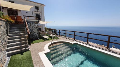康加德马里尼Villa Sunrise. Pool and seaview in Amalfi Coast的一座位于海边的别墅旁的游泳池