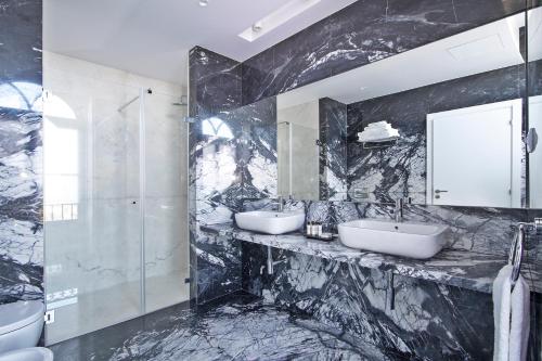 辛特拉Villa Bela Vista的黑色大理石浴室设有2个盥洗盆和淋浴。