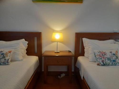 雷根古什-迪蒙萨拉什Terras de Monsaraz的一间卧室设有两张床和一张桌子上的台灯。