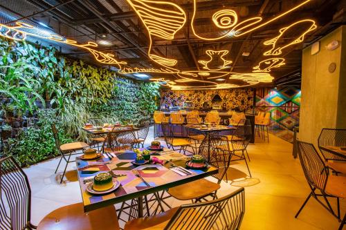 帕斯托Hotel V1501的一间设有桌椅的餐厅,种植了植物