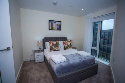 伦敦UNIQUE 2 BED APARTMENT的一间卧室设有一张床和一个大窗户