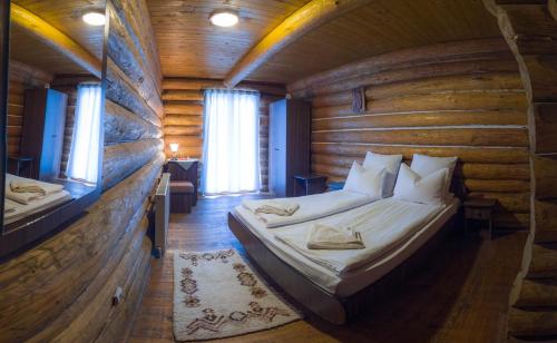 博尔塞克Papa la Șoni Gastro-Pensiune的小木屋内一间卧室,配有一张床