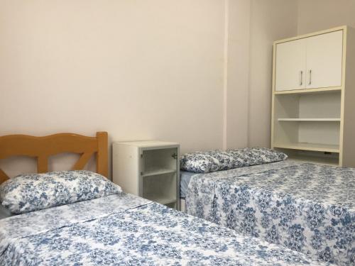 拉古纳APARTAMENTO 3 DORM., O QUINTAL É A PRAIA E MOLHES的一间设有两张蓝色和白色床单的房间