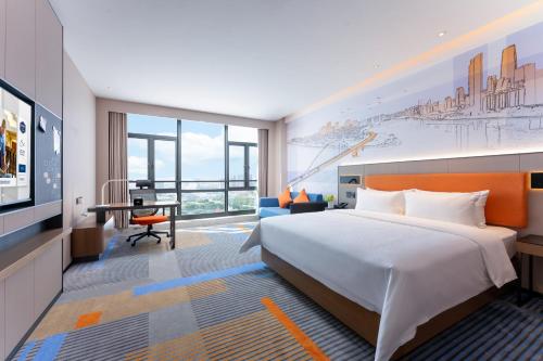 广州广州金沙洲希尔顿欢朋酒店的配有一张床和一张书桌的酒店客房
