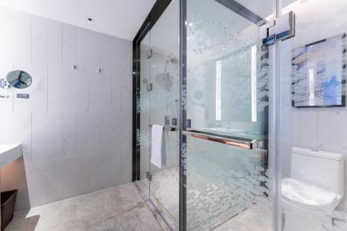 广州广州金沙洲希尔顿欢朋酒店的浴室设有玻璃淋浴间和卫生间